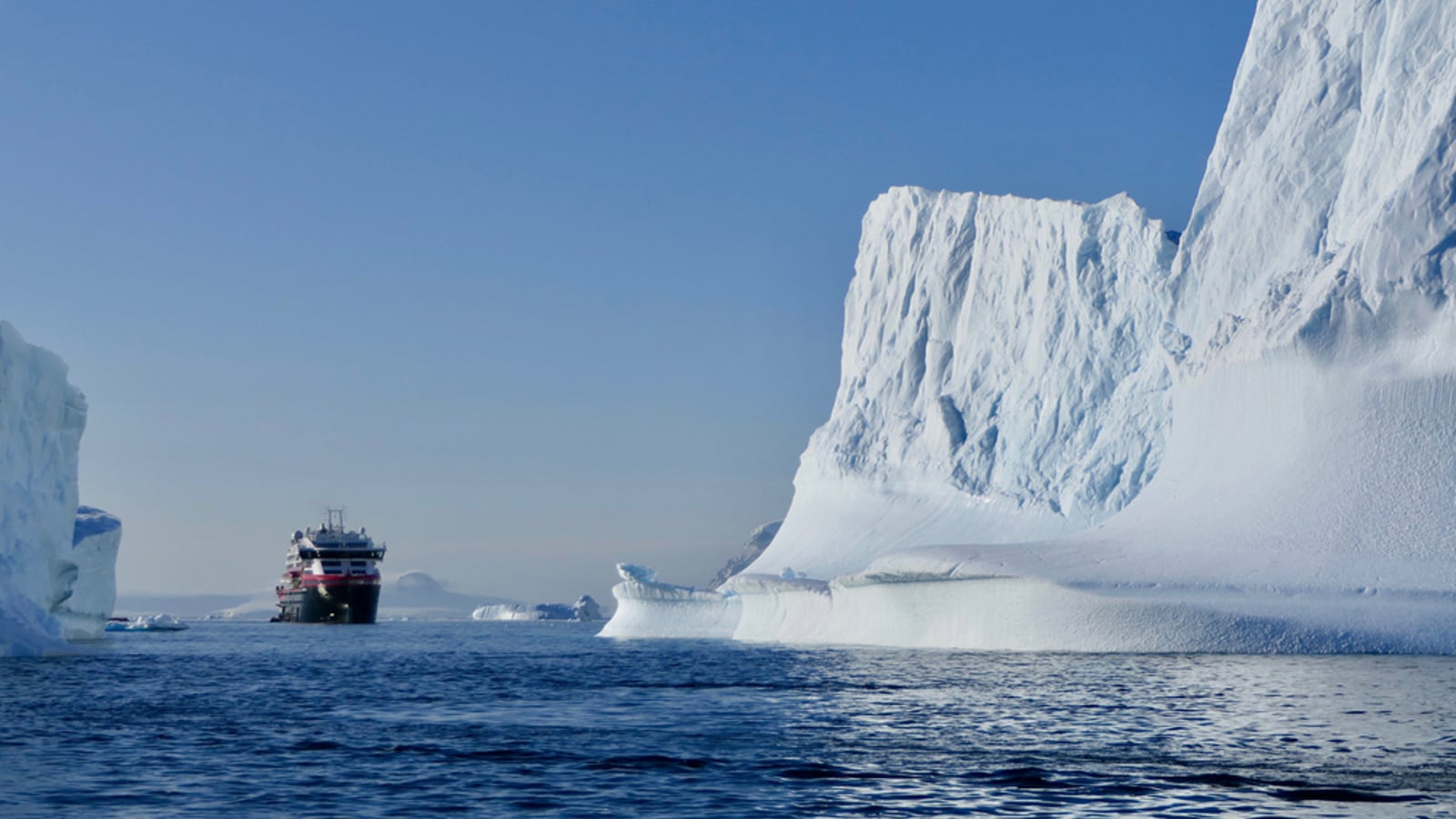 Cruise ship between icebergs in antarctic ocean shutterstock_1789480382