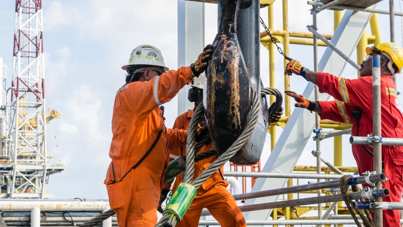 Offshore construction crews preparing the crane block for a heavy lifting