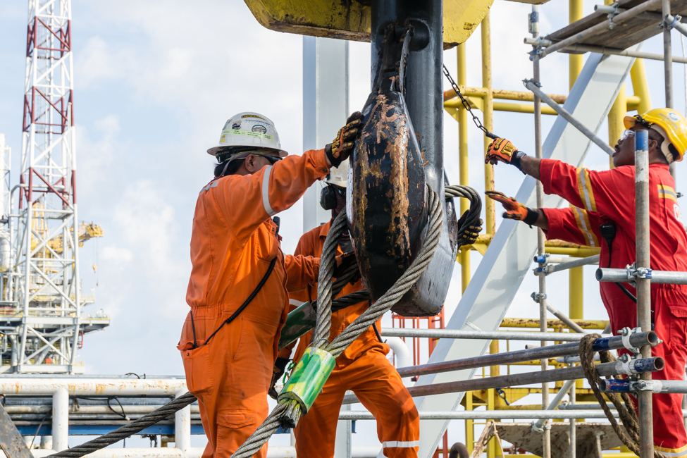 Offshore construction crews preparing the crane block for a heavy lifting