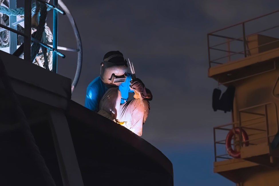 Welder working on ship at night